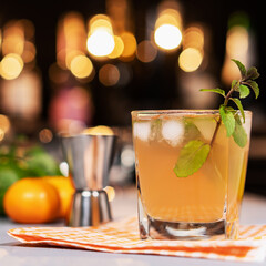 Fresh cocktail with lime, mint and ice on the background of the bar.