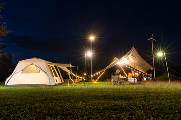 Night camping atmosphere. It is a low-light night shot with noise and grain. Long exposure photography causes moving parts to blur. There will be sharpness only at the selected focus point.