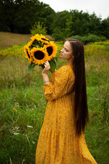 girl smelling a sunflower in a field