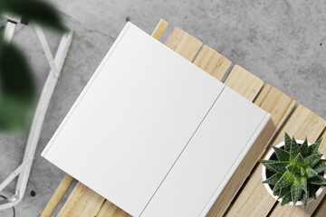 Clean minimal cover square book mockup on top wooden with plants