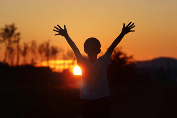 Dream and hope, challenge and success freedom concept silhouette with child with arms outstretched...