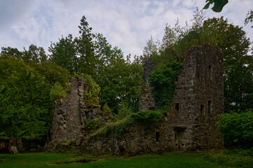Fototapeta na wymiar A ruin of Finlarig Castle surrounded by green trees and bushes