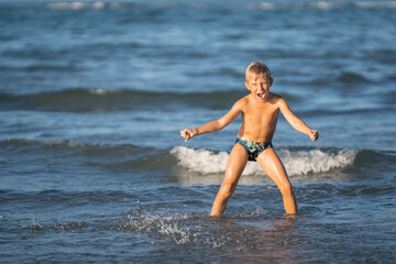Happy little boy  shouting on the shore, Child enjoying active summer, holiday in beach resort.summer concept holiday, Emilia Romagna, Italy.