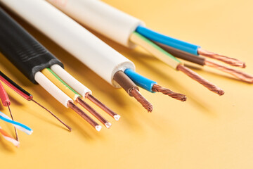 Electric cables, many copper wires with colored isolation isolated on yellow background