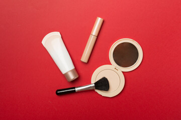 Makeup products for skin tone on color background, top view