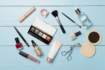 Different makeup products on wooden background, top view