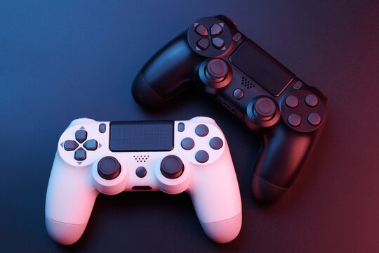 Two video game controllers, joysticks for game console isolated on black background. Gamer controlling devices close-up