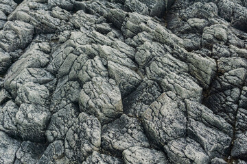 natural stone background, the gray rough lava basalt rock