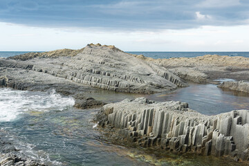 coastal rocky shore formed by columnar basalt at low tide