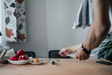 Fototapeta na wymiar Man hands serving table for breakfast in kitchen dining room.