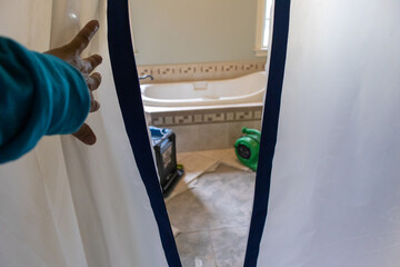 worker removing mold from bathroom