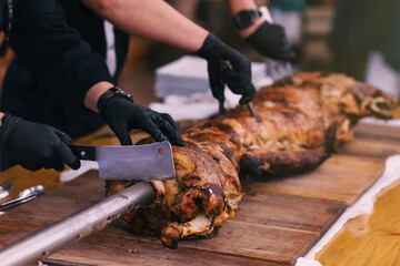 men's hands cut on the table a large piece of meat on a wooden board.