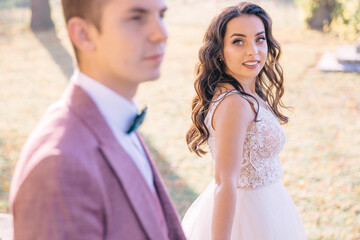Obraz premium the bride looks at her husband with a loving look while walking after the ceremony with him.