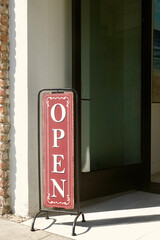 vintage metal vertical OPEN sign in front of store