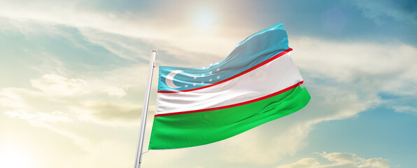 Uzbekistan national flag cloth fabric waving on the sky - Image
