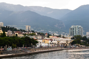 A city on the seashore. Against the background of mountains.