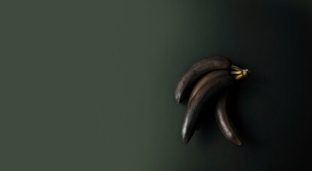 Bananas with a blackened peel on a dark background. Monochrome. Minimal composition. Modern design poster