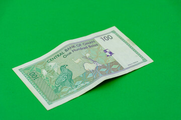 Oman riyal banknote on a green background. Selective focus.