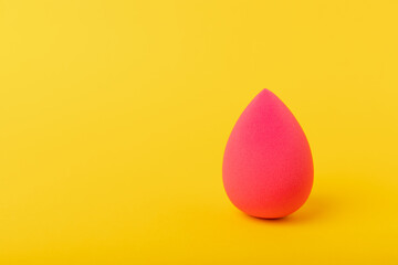 Beauty blender on a yellow background.Sponge for makeup cosmetics. Makeup products. Beauty concept. Place for text. Space for copy. Flat lay