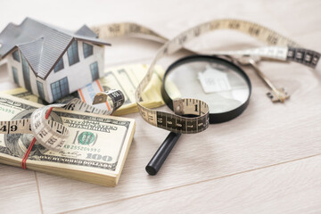 dollar money, toy house and magnifying glass