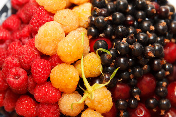 Berries plate, ripe assorted, cherries, white and red raspberries and currants. Focus on red raspberries and currants