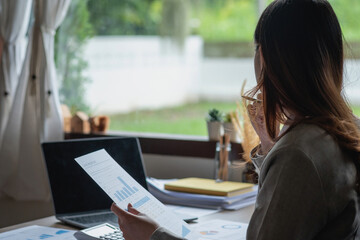 marketing, finance, accounting, planning, female accountant using laptop calculator and documents, charts, graphs in the analysis of the company's profit