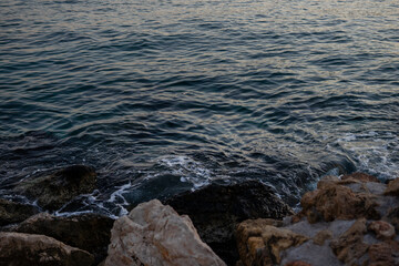 Fototapeta na wymiar waves on the beach at sunset. rocks and sea.