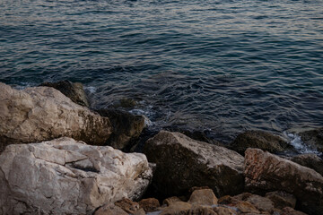 waves on the beach at sunset. rocks and sea.
