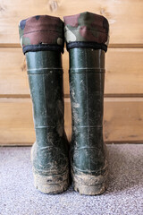 Muddy dirty rubber boots after working in garden in spring