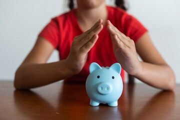 Little girl saving money in a piggybank over a white background