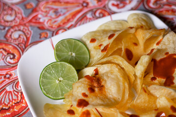 Papas fritas con salsa picante y limón partido 
