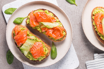 Open sandwich with smoked and salted salmon for healthy breakfast. Trout and avocado on bruschetta toast. 