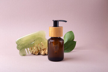 Eco friendly cosmetics dispenser with hair brush near it.Green leafs on background.Concept of hair...