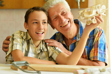 Grandfather and his grandson made an airplane model