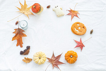 Autumn composition. Pumpkins, candles, dried leaves and kookies on white background. Autumn, fall, halloween concept. Copy space. Flat lay, top view