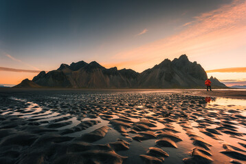 Sunrise over Vestrahorn mountain with rippled black sand beach in summer on Stokksnes peninsula at...