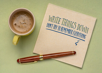 write things down, don't try to remember everything - inspirational productivity tip on a napkin with a cup of coffee