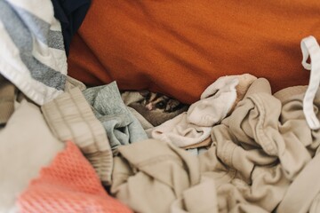 Little Sugar Glider hiding in the pile of clothes and looking up cautiously.