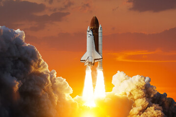 Spaceship lift off. Space shuttle with smoke and blast takes off into space on a background of sunset. Successful start of a space mission. Elements of this image furnished by NASA.