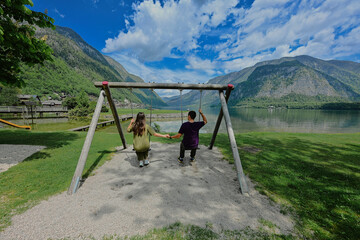 Fototapeta premium Couple swinging holding hands at Hallstatt, Austria.