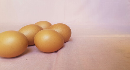 Some eggs are laid on a pink cloth.