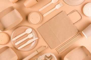 Paper utensils and wooden cutlery set over brown background. Street food sustainable paper packaging, green and zero waste packaging concept. Flat lay style
