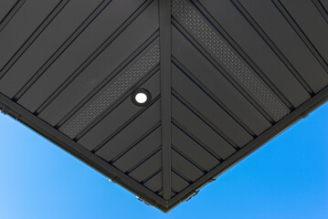 A modern graphite herringbone roof lining is attached to the trusses, visible turned on LED lights.