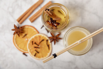 Set for making candles on a wooden background. Pouring soy wax into glass. Candles with dried flowers and spices. Eco soy wax on a white table. Candle with your own hands. Hobby concept.Place for text