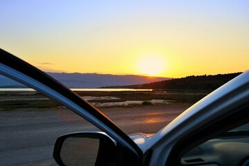 Piękny wschód słońca nad Morzem Adriatyckim, widziany oczami kierowcy, po dotarciu do celu podróży - obrazy, fototapety, plakaty
