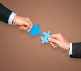 Human hands hold a puzzle piece for teamwork concept