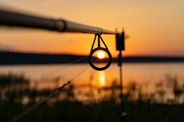 The sunset looked through the guide of the fishing rod