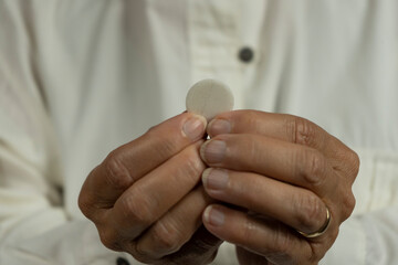 A woman holding a bread wafer for communion in a Christian church
