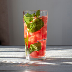 Lemonade with mint and watermelon on a silver wooden background. Square photo.