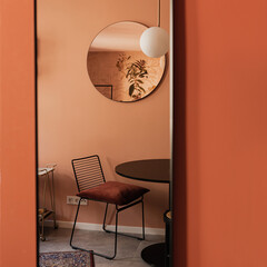 Elegant stylish chair, table, mirror, carpet, colourful coral walls. Modern aesthetic minimalist...